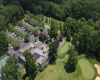 trees, building, parking lot, cars, golf course trees, building, parking lot, cars, golf course